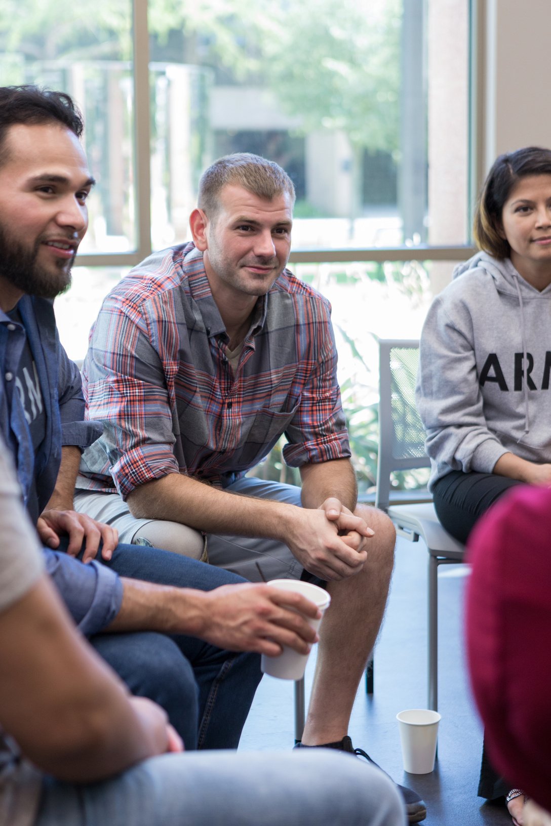 Male veteran listens to fellow veteran during group therapy session